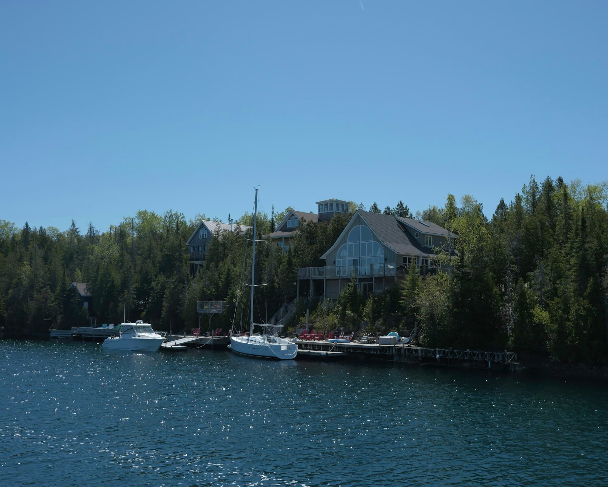 Lakefront homes and docks below forested hills